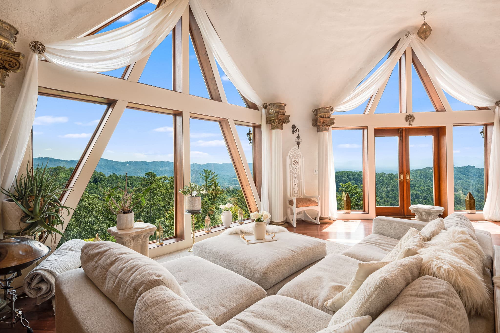 Grand living room interior with cathedral windows opening to the mountains — an example of Azura's design work