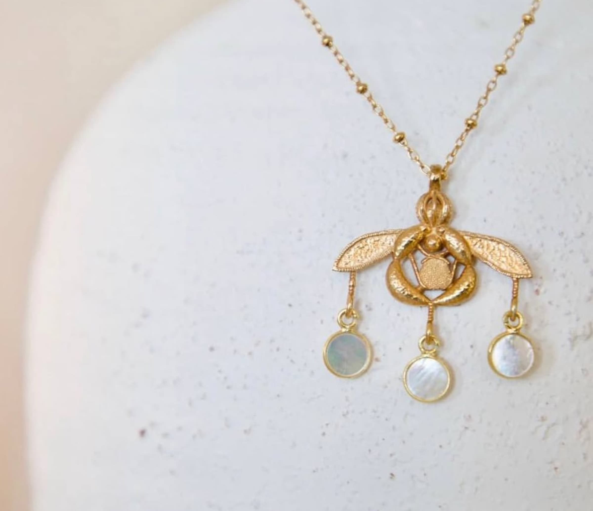 Amari — golden bee pendant necklace with mother-of-pearl drops