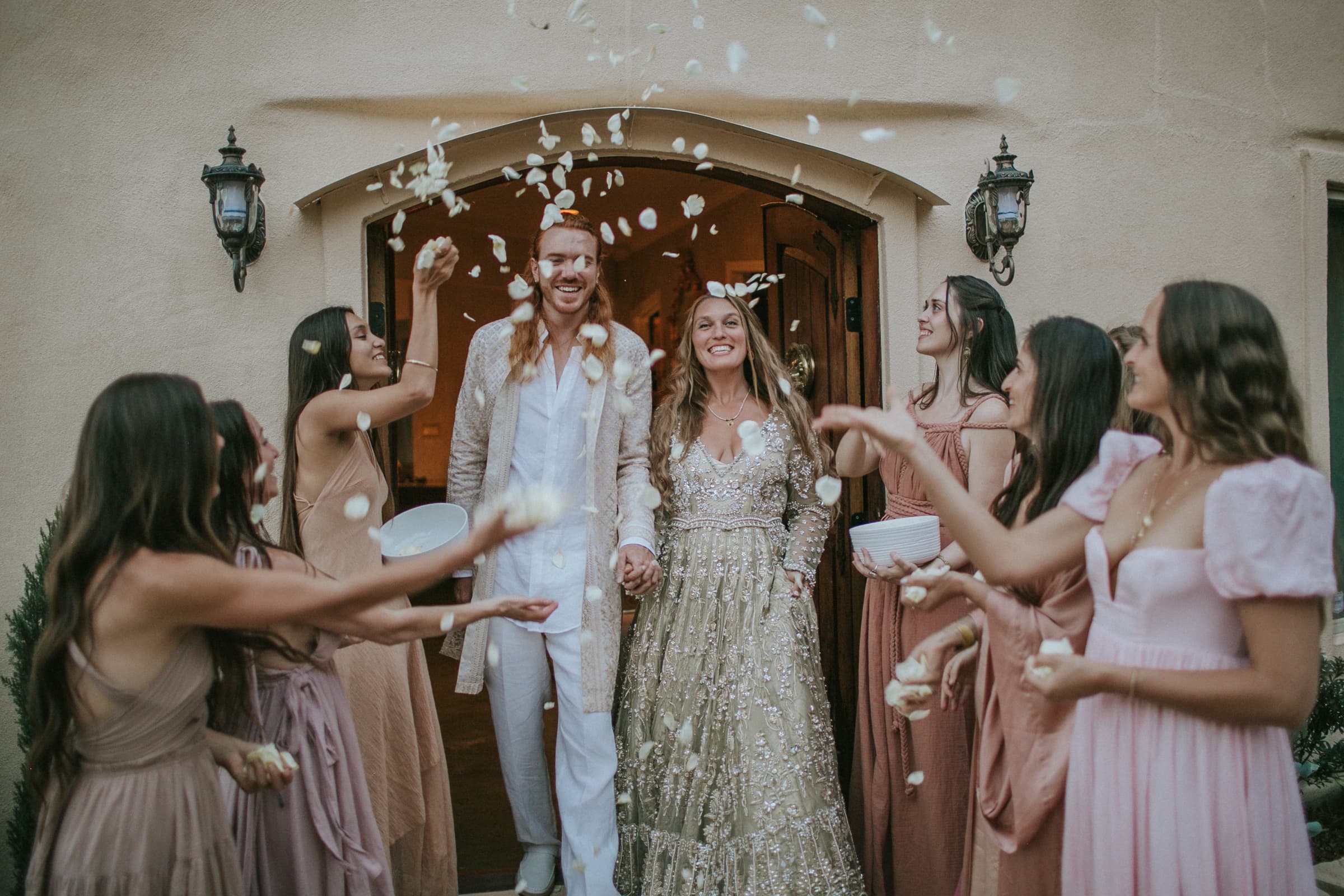 Petal-toss recessional at the dome home's arched entrance